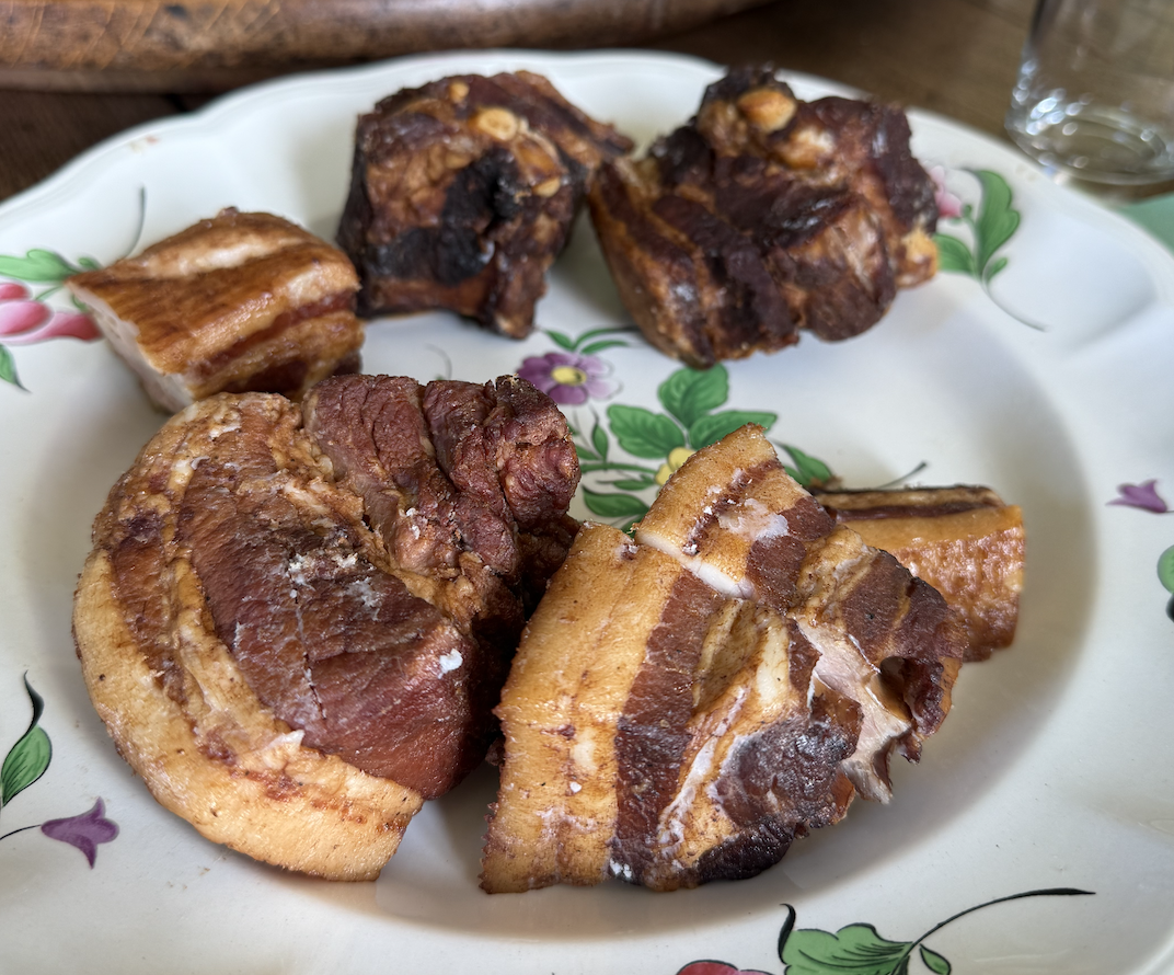Une assiette de rillons de porc, aux couches visibles de gras et de viande.